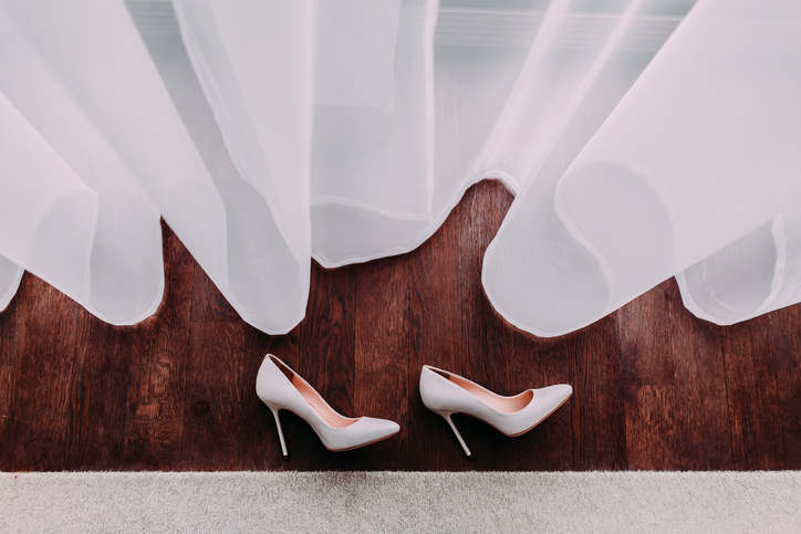 White heels atop of a dark-stained floor